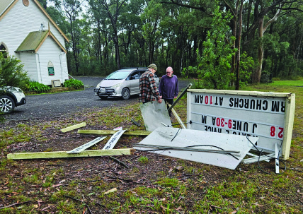 Residents clearing up the demolished church sign