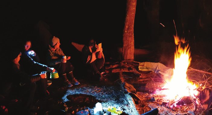 People gathered around a campfire at night